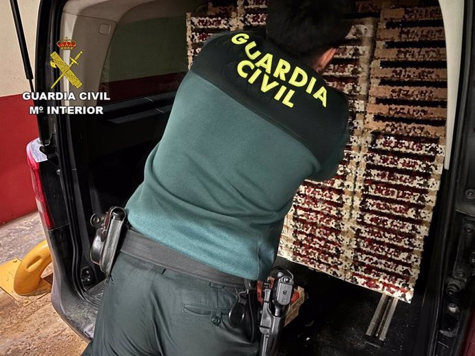 Un agente de la Guardia Civil con la fruta intervenida en el almacén.
