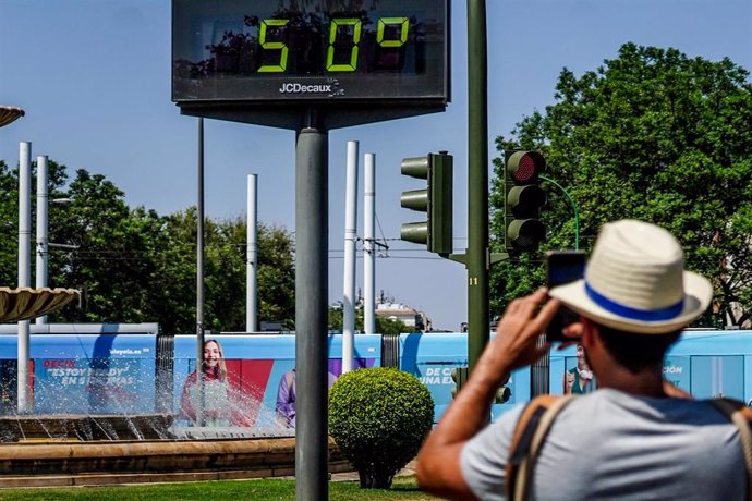 Archivo - Transeúntes fotografían el termómetro situado en el Prado que marca 50 grados, a 26 de junio del 2023 en Sevilla (Andalucía, España).