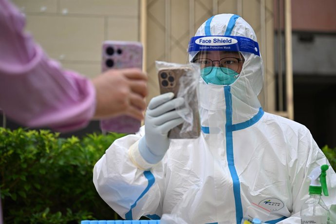 Archivo - SANYA, 9 de agosto de 2022 -- Zhou Shixun, um turista que se tornou voluntário de Wuhan, na província de Hubei, no centro da China, registra informaes sobre testes de ácido nucleico em uma área residencial em Sanya, província de Hainan, no s