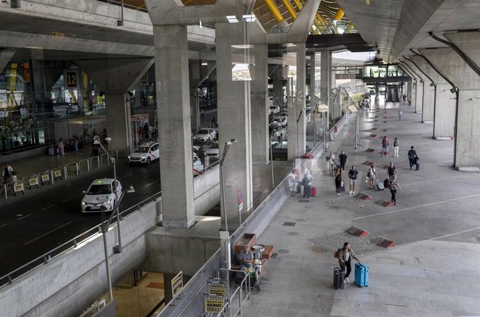 Archivo - Varias personas en la terminal T4 del aeropuerto Adolfo Suárez Madrid-Barajas 