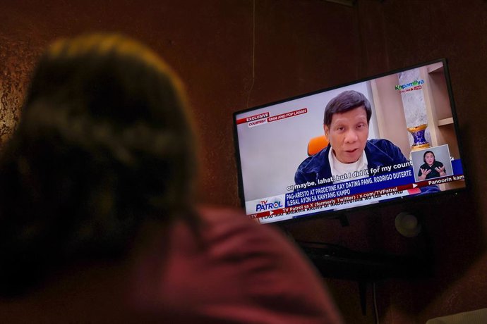 QUEZON CITY, March 12, 2025  -- A woman watches the news about former Philippine President Rodrigo Duterte in Quezon City, the Philippines, March 12, 2025. Philippine President Ferdinand Romualdez Marcos confirmed that a chartered jet carrying former Pres