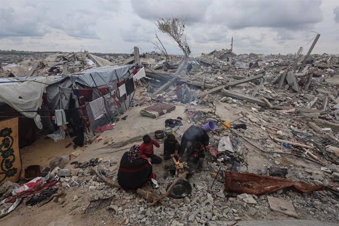 Una mujer palestina, cuya casa quedó completamente destruida en los ataques israelíes en la Franja de Gaza, instala una tienda de campaña improvisada sobre los escombros de su vivienda derruida en Beit Lahia