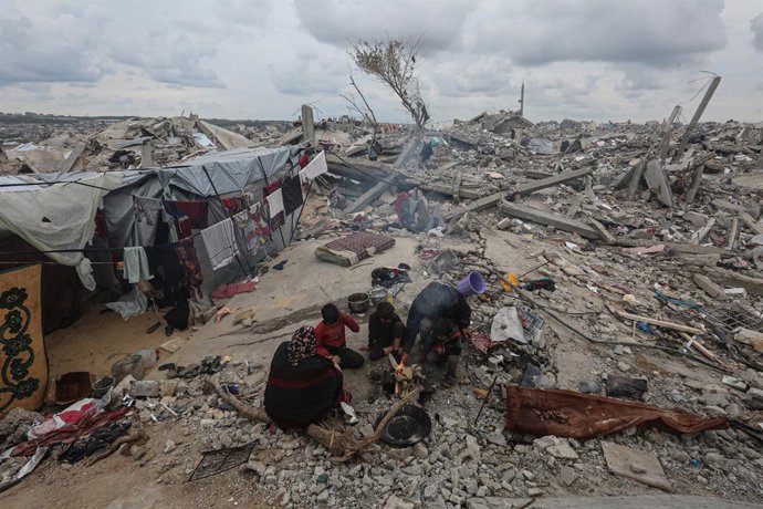 Uma mulher palestina, cuja casa foi completamente destruída pelos ataques israelenses na Faixa de Gaza, monta uma tenda improvisada nos escombros de sua casa destruída em Beit Lahia.