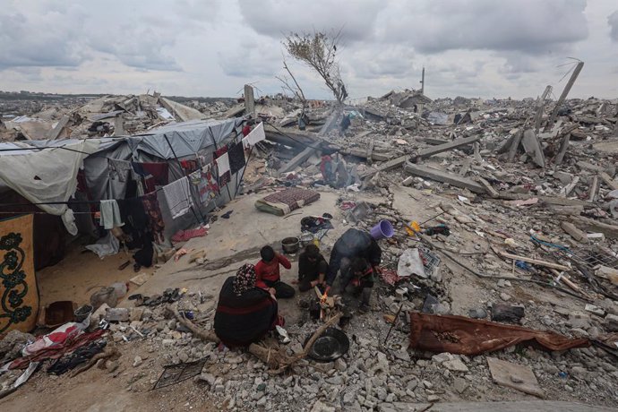 Una mujer palestina, cuya casa quedó completamente destruida en los ataques israelíes en la Franja de Gaza, instala una tienda de campaña improvisada sobre los escombros de su vivienda derruida en Beit Lahia