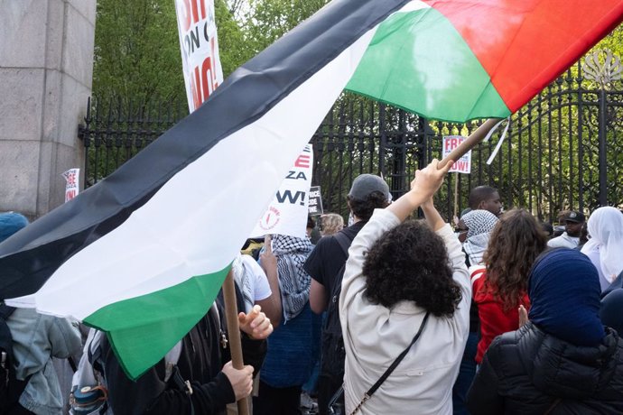 Archivo - Arxiu - Una estudiant oneja una bandera palestina enfront de la Universitat de Columbia, Nova York
