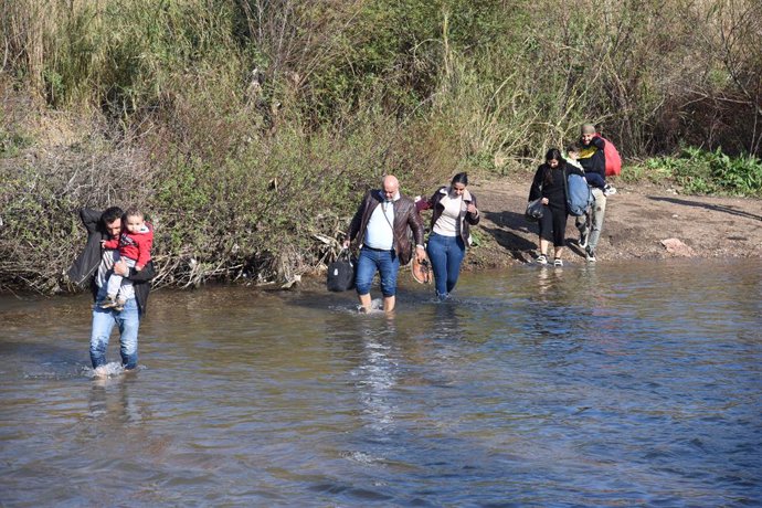 AKKAR, March 13, 2025  -- Syrian citizens wade through a river along the Syria-Lebanon border to enter Lebanon's northern Akkar region on March 12, 2025. TO GO WITH "Thousands of Syrians flee to Lebanon amid coastal region violence"