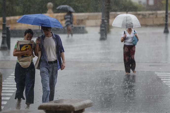 Archivo - Arxiu - Diverses persones amb paraigües baix la pluja en imatge d'arxiu