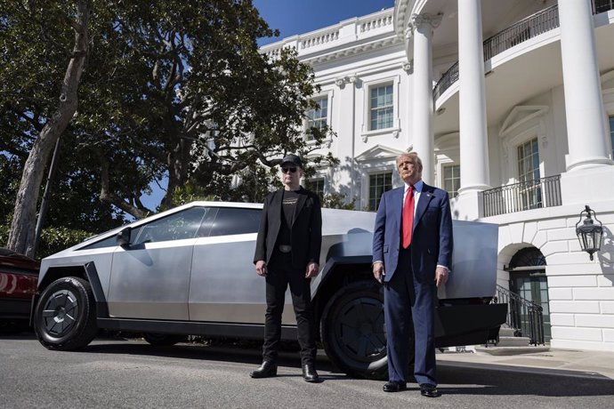 FILED - 11 March 2025, US, Washington: U.S President Donald Trump, (R), stands with billionaire Elon Musk by a Tesla Cybertruck on the South Lawn of the White House. Trump came to the defense of Musk and Tesla after shares in the company dropped 15\% in o