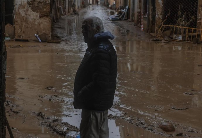 Archivo - Un hombre pasea por la calle anegada de barro, a 13 de noviembre de 2024, en Paiporta, Valencia (archivo)