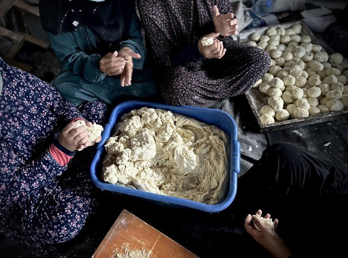 Archivo - Arquivo - 21 de novembro de 2024, Khan Yunis, Faixa de Gaza, Território Palestino: Mulheres palestinas fazem pão como parte de uma iniciativa de caridade para alimentar centenas de pessoas deslocadas no campo de Al-Mawasi, designado como área hu