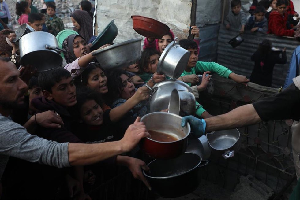 Niños y mayores tratan de conseguir comida en el campo de refugiados de Yabalia, en el norte de la Franja de Gaza