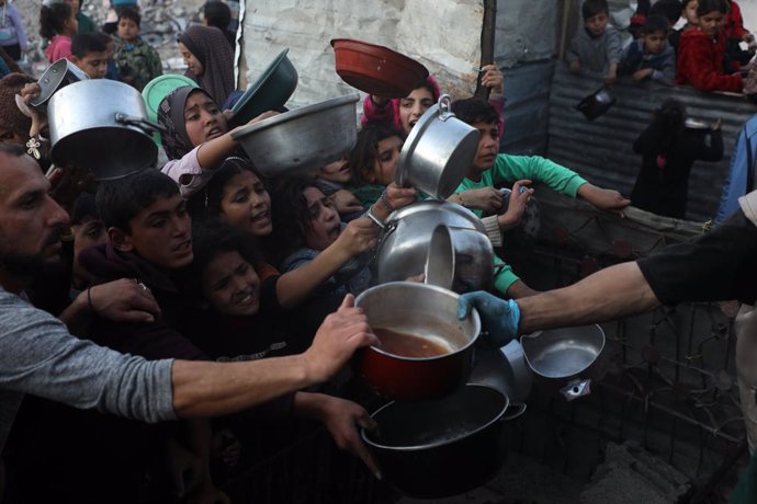 JABALIA, March 11, 2025  -- People try to get food at a charity kitchen in Jabalia refugee camp, northern Gaza Strip, on March 11, 2025. The humanitarian situation in the Gaza Strip continues to deteriorate as Israel has kept all border crossings closed a