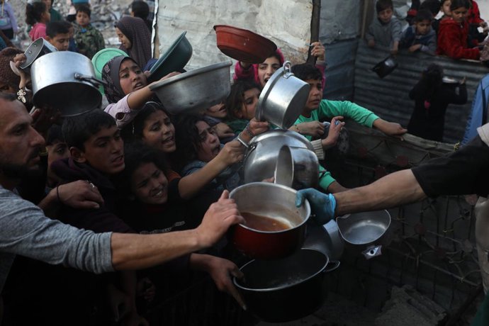 JABALIA, 11 de março de 2025 -- Pessoas tentam conseguir comida em uma cozinha beneficente no campo de refugiados de Jabalia, no norte da Faixa de Gaza, em 11 de março de 2025. A situação humanitária na Faixa de Gaza continua a se deteriorar, já que Israe