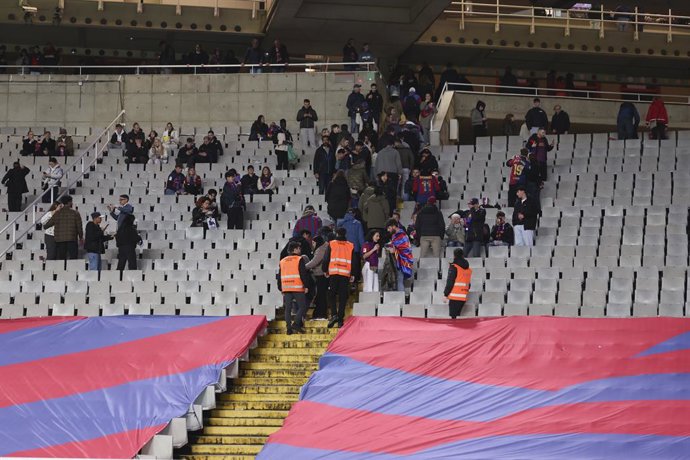 Torcedores deixam as arquibancadas depois que a partida foi cancelada devido à morte de Carlos Minarro antes do jogo de futebol da Liga Espanhola, LaLiga EA Sports, disputado entre o FC Barcelona e o CA Osasuna no Estadi Olimpic Lluis Companys em 08 de ma