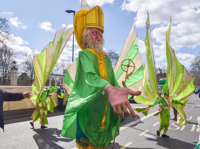 March 16, 2025, London, England, UK: A performer wearing a giant St Patrick costume takes part in the St Patrick's Day parade in Central London.