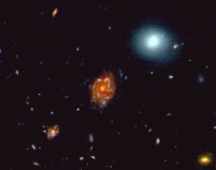 Esta imagen RGB mejorada de 25 segundos de arco de ancho muestra la galaxia "Gran Rueda" con un corrimiento al rojo de 3,25, un gigante cósmico cuya luz ha viajado más de 12 mil millones de años para llegar hasta nosotros.