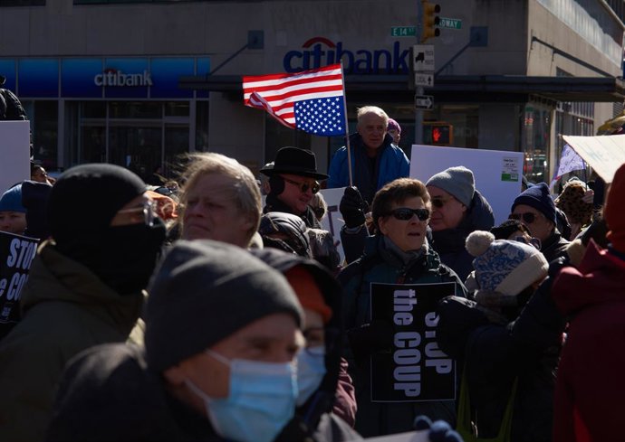 17 de fevereiro de 2025, Nova York, Nova York, EUA: Um manifestante segura uma bandeira americana de cabeça para baixo na Union Square no Dia do Presidente para um protesto nacional do Dia de Não Meus Reis, em que milhares de pessoas se reuniram para expr