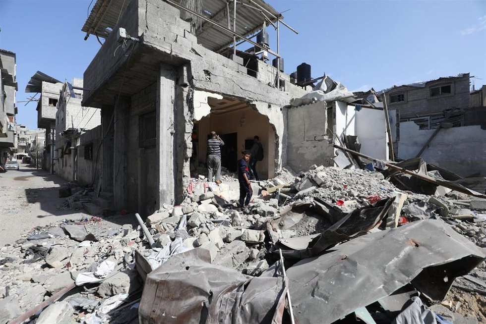 Civiles palestinos inspeccionan un edificio destruido en Nuseirat, en la Franja de Gaza