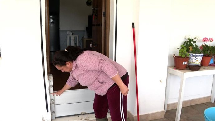 Vecina rescatada por los bomberos en Los Palmares por las inundaciones generadas por la borrasca señala hasta donde llegaba el agua en su casa.