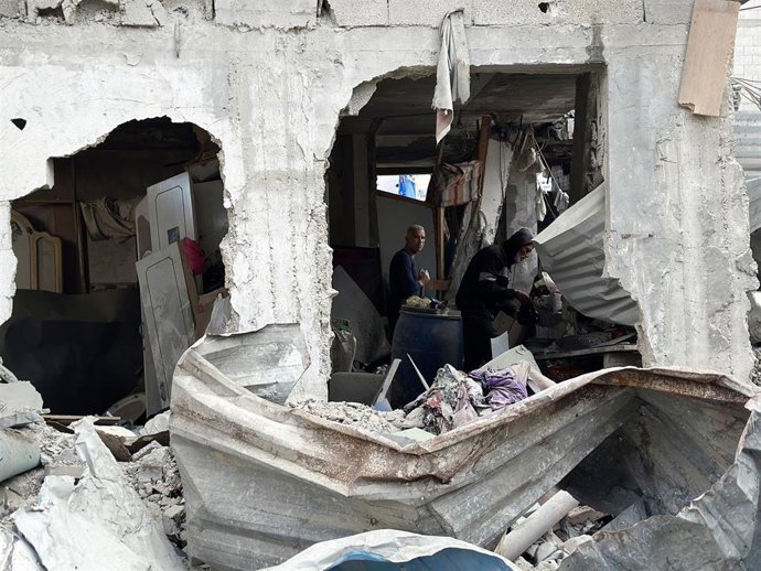 Civiles palestinos buscan entre los escombros de un edificio destruido en Jan Yunis, en la Franja de Gaza