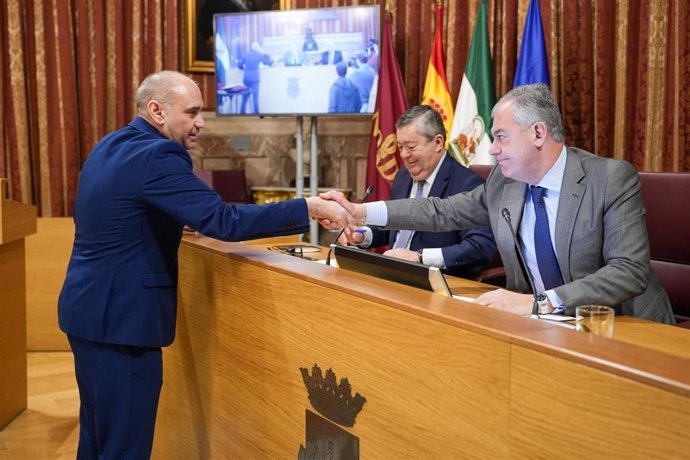 Antonio Díaz Arroyo saluda al alcalde de Sevilla tras jurar su cargo en el Salón Colón del Consistorio.