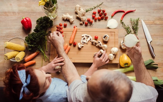 Archivo - Pareja cocinando verduras.