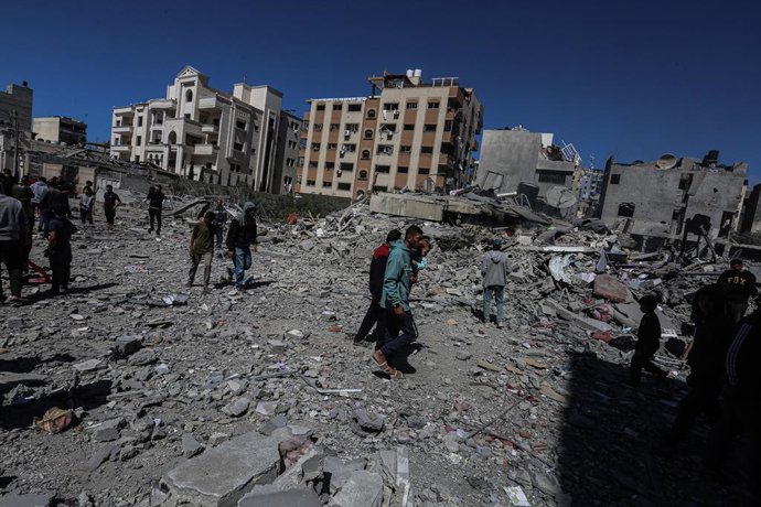 Palestinos em frente a prédios destruídos por ataques do exército israelense na Cidade de Gaza, no norte da Faixa de Gaza.