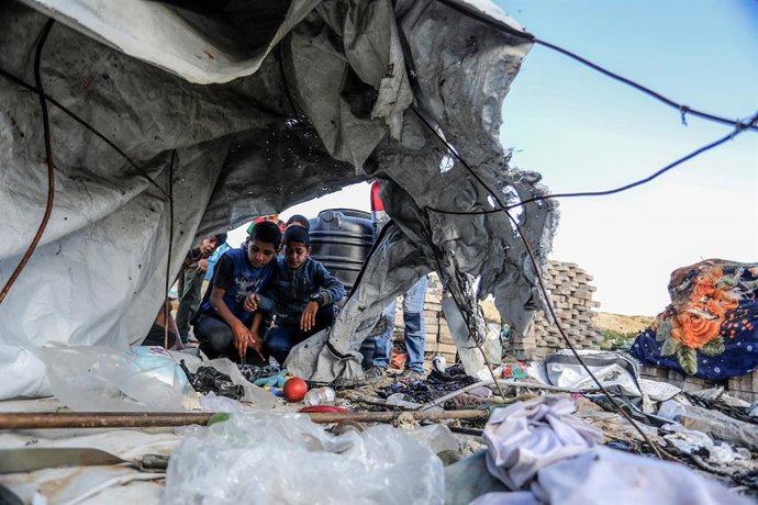 19 de março de 2025, Territórios Palestinos, Khan Younis: Crianças palestinas sentadas no meio dos danos causados por um ataque aéreo israelense em Khan Younis. O exército israelense continua com seus pesados ataques aéreos em Gaza como forma de pressiona