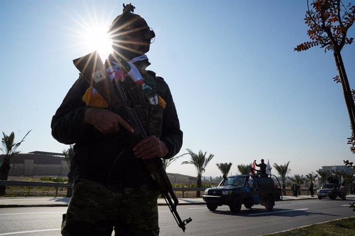 Archivo - December 10, 2024, Mosul, Iraq: An Iraqi soldier stands while members of Iraq's Popular Mobilization Forces ride a military vehicle during a military parade celebration of ''Victory Day'' marking the seventh anniversary of the defeat of Islamic 