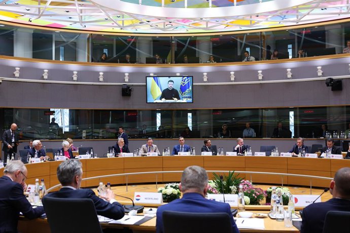 Líderes da UE no Conselho Europeu com o presidente ucraniano Volodymyr Zelenski falando por videoconferência.