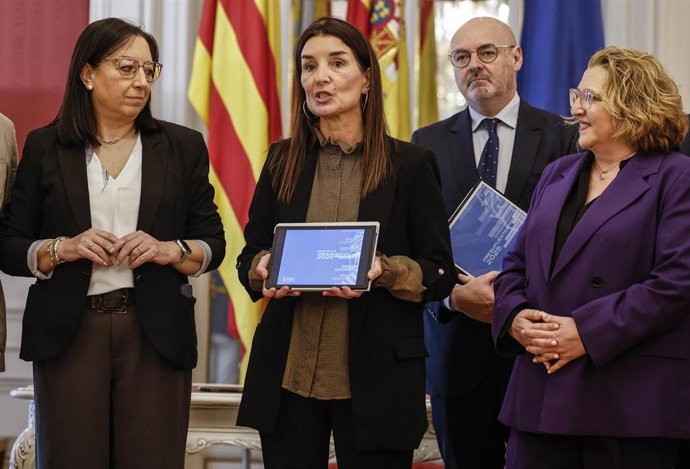 La presidenta de Les Corts de Valencia, Llanos Massó (i), recibe de la consellera de Hacienda y Economía, Ruth Merino (c), el proyecto de Ley de Presupuestos 2025, en Les Corts, a 20 de marzo de 2025, en Valencia