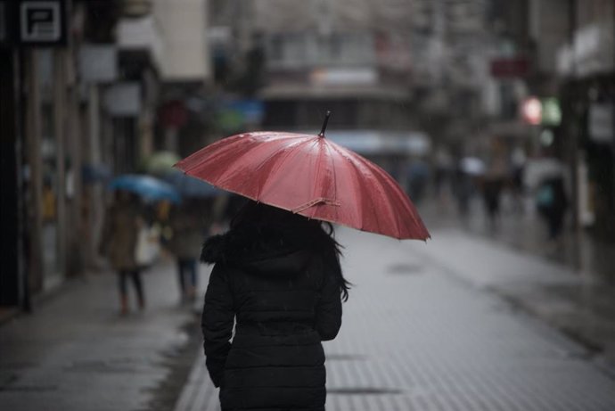 Archivo - Una persona con paraguas para protegerse de la lluvia camina por la Rua Michelena, a 16 de enero de 2023, en Pontevedra, Galicia (España).  