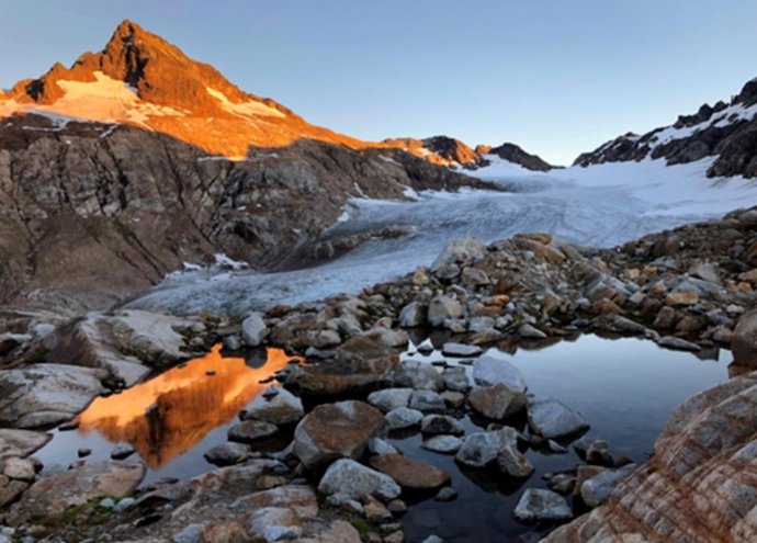Sentinel Peak iluminado ao pôr do sol ao lado da geleira South Cascade na Cascade Range (EUA).
