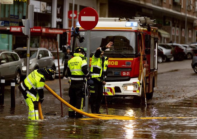 Archivo - Bomberos evacúan una balsa de agua en Madrid.