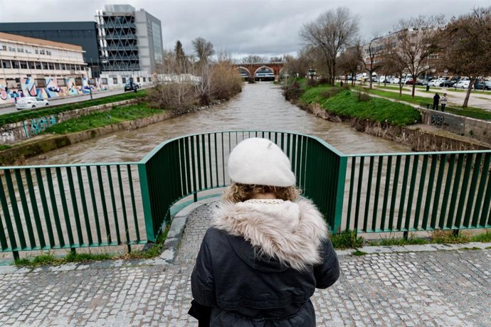Una mujer observa el río Manzanares a su paso por el puente de los Franceses, a 21 de marzo de 2025, en Madrid (España). El alcalde de Madrid, José Luis Martínez-Almeida, ha asegurado que la ciudad se encuentra en situación de "estabilidad" tras las inten