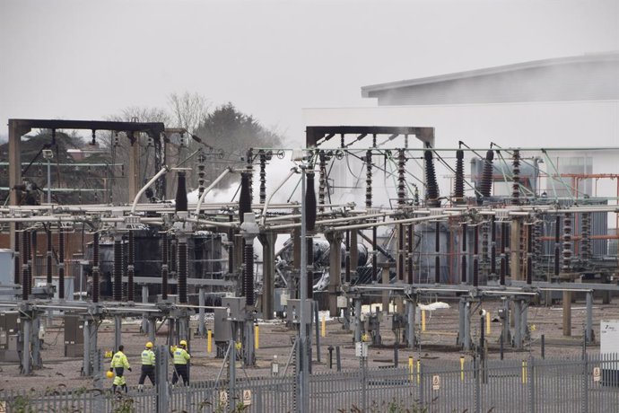 March 21, 2025, London, United Kingdom: Emergency service personnel inspect the scene as smoke billows after a fire broke out at the North Hyde Electricity Substation in Hayes, causing the nearby Heathrow Airport to close with thousands of flights affecte