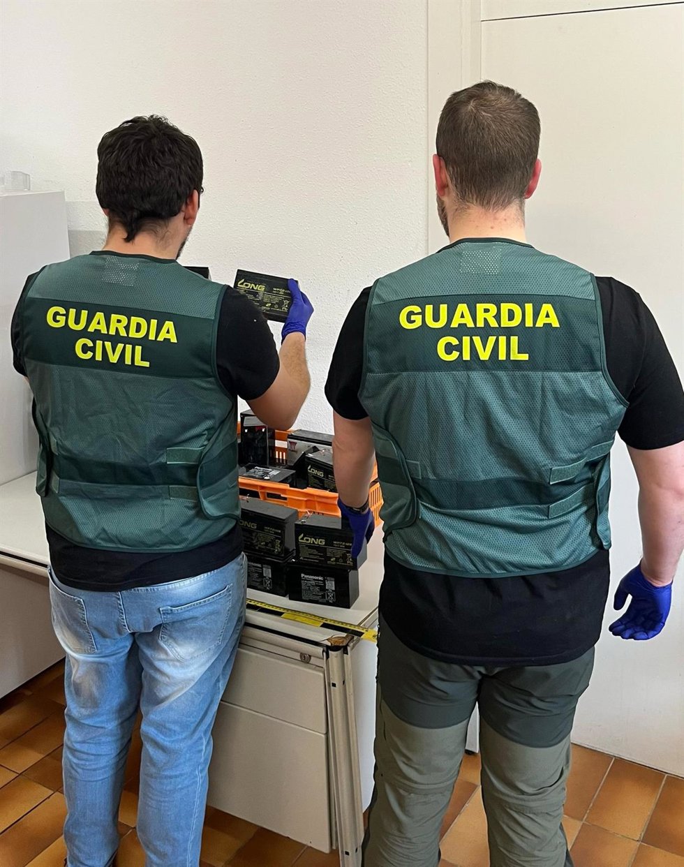 Dos agentes examinan el material incautado