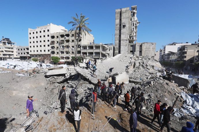 March 23, 2025, Gaza City, Gaza Strip, Palestinian Territory: Palestinians inspect a crater at the site of Israeli strikes on a makeshift displacement camp in central Gaza City on March 23, 2025