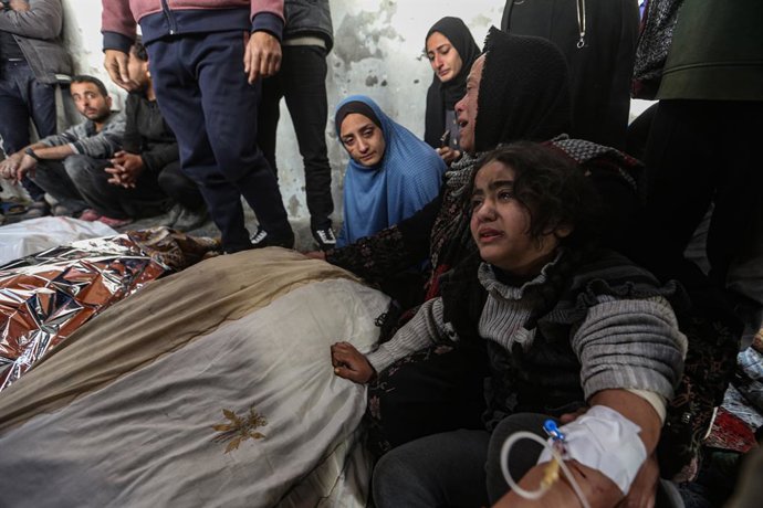 Palestinos no Hospital Batista Al Ahli, na Cidade de Gaza, ao lado dos corpos de várias pessoas mortas em ataques do exército israelense na Faixa de Gaza.