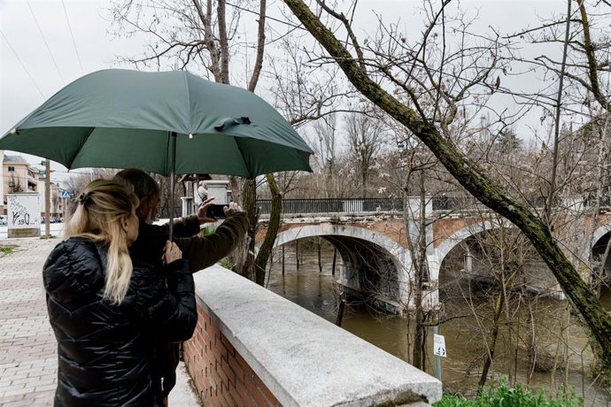 Dos personas observan el río Manzanares a su paso por El Pardo, a 21 de marzo de 2025, en Madrid (España). 