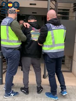 El detenido, conducido por agentes de policía.