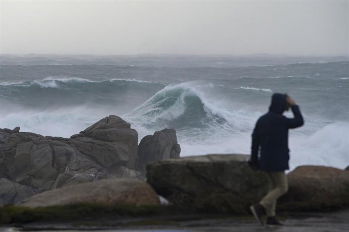 Archivo - Una persona camina por el paseo marítimo observando el mar embravecido, a 4 de noviembre de 2023, en A Coruña, Galicia (España).