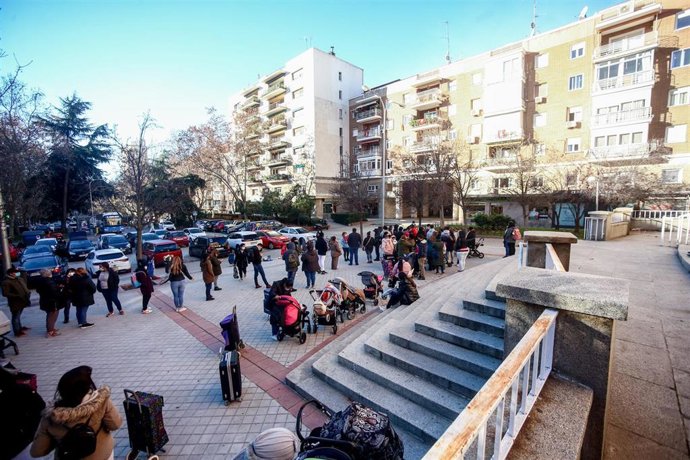 Archivo - Una hilera de personas espera para recibir alimentos en un reparto organizado por la Fundación Madrina.