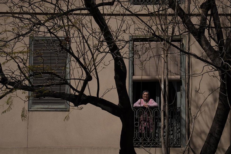 Archivo - Una mujer asomada a la ventana, a 25 de abril de 2023, en Barcelona, Catalunya (España)