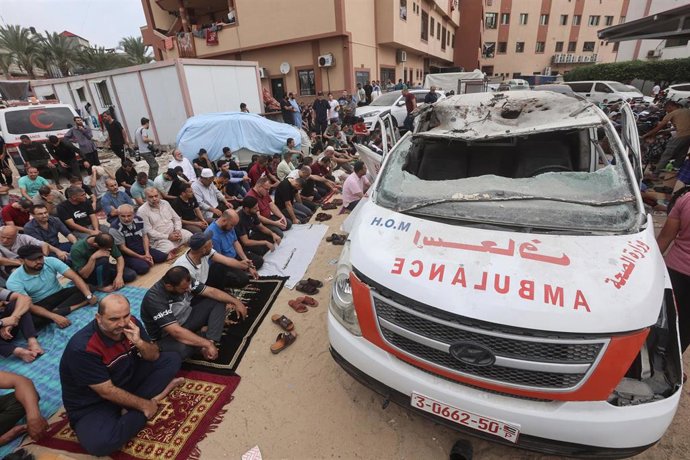 Archivo - Imagen de archivo de ciudadanos palestinos en torno a una ambulancia alcanzada por un misil de Israel