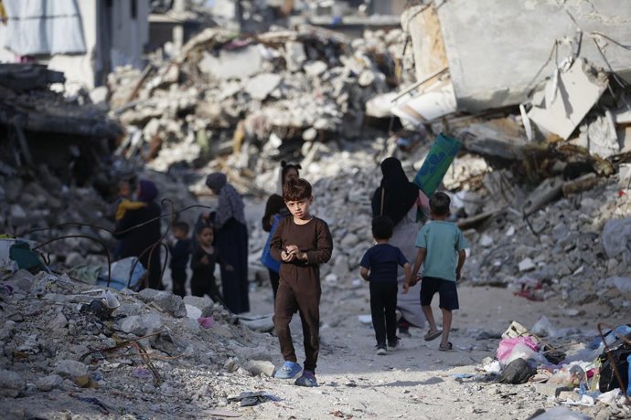 GAZA, 18 de março de 2025 -- Palestinos caminham entre prédios destruídos em Jabalia, no norte da Faixa de Gaza, em 17 de março de 2025.