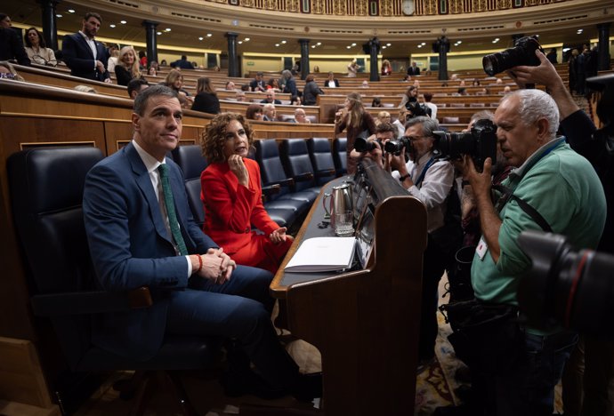 El presidente del Gobierno, Pedro Sánchez y la vicepresidenta primera y ministra de Hacienda, María Jesús Montero, son fotografiados durante una sesión plenaria en el Congreso de los Diputados, a 26 de marzo de 2025, en Madrid (España).