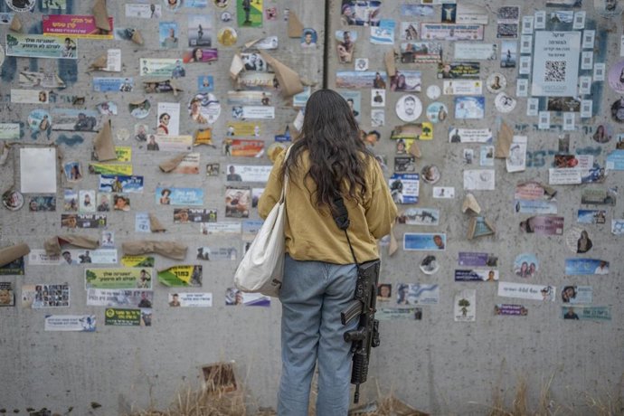 Archivo - Una mujer frente a las fotografías de víctimas del ataque ejecutado el 7 de octubre de 2023 contra el festival de música Nova durante la conmemoración del primer aniversario de la matanza (archivo)