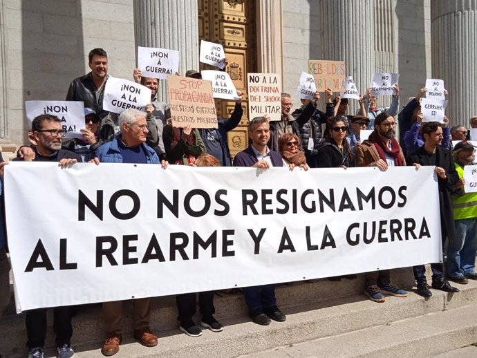 Os coletivos e atores sociais Carolina Yuste e Juan Diego Botto apresentam o manifesto contra o plano de rearmamento da UE intitulado "Não nos conformamos com o rearmamento e a guerra na Europa" nos portões do Congresso.