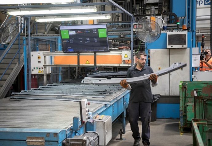 Archivo - Trabajador en fábrica de componentes vehículos (industria)